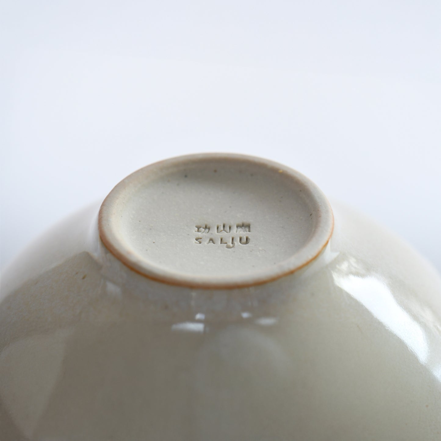 Bottom view of Yuhaku matcha bowl with Kozan Kiln stamp and foot ring detail