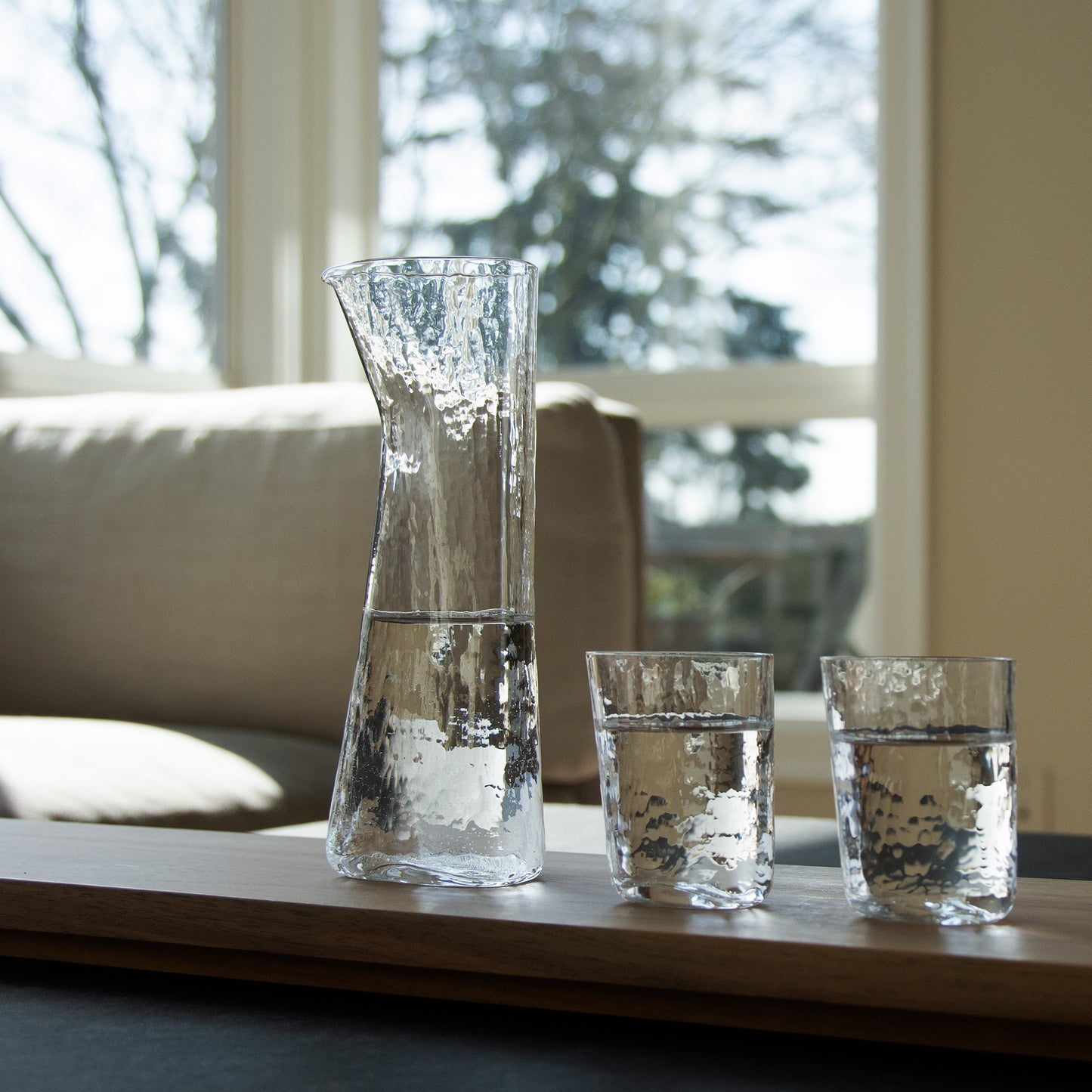 Carafe and two cups are in line at the living room. Warm cosy feeling.