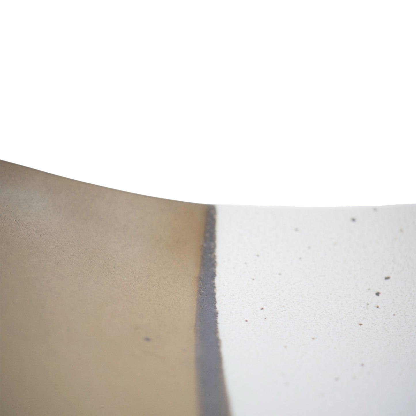 Close look of the edge of the table. The white part has small black speckles and there is dark brown line in between with the gold.