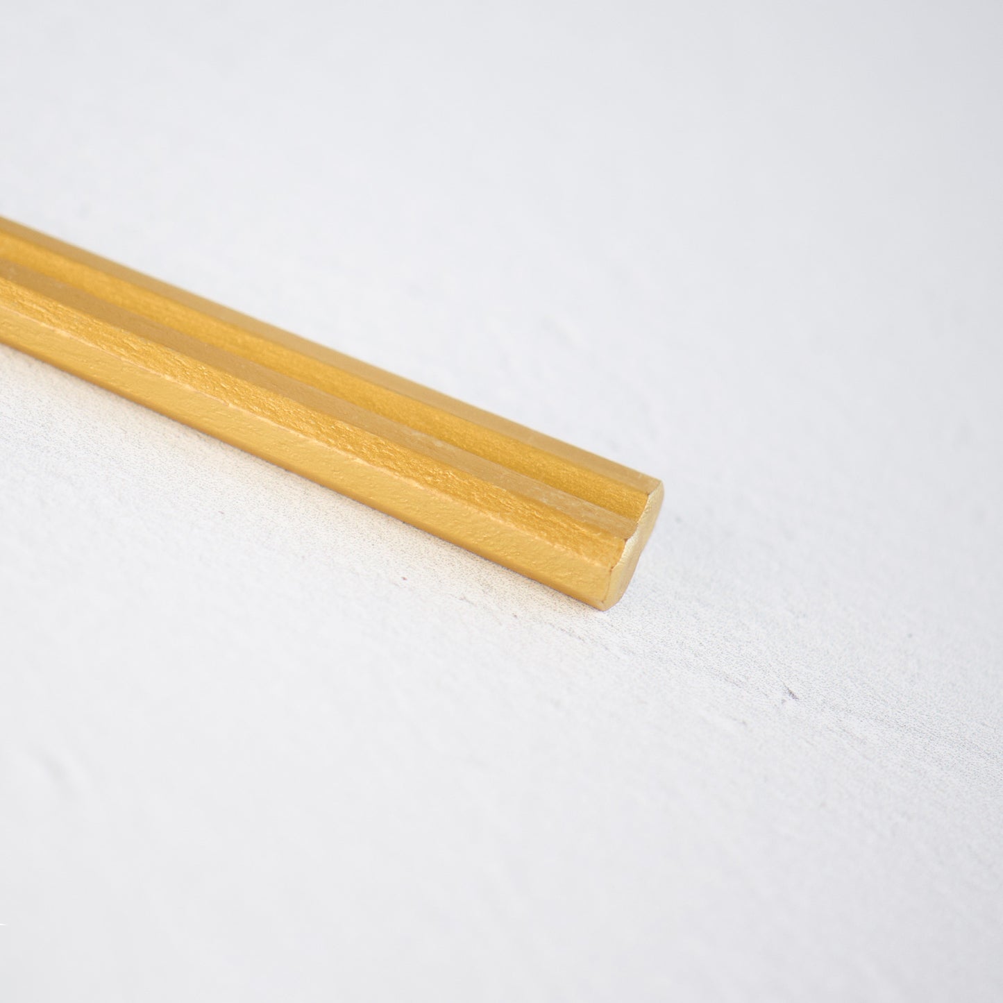 A close-up view of the elaborate gold-plated with lacquerheads of a pair of chopsticks, exquisitely crafted for a touch of luxury. Modern and sleek design.