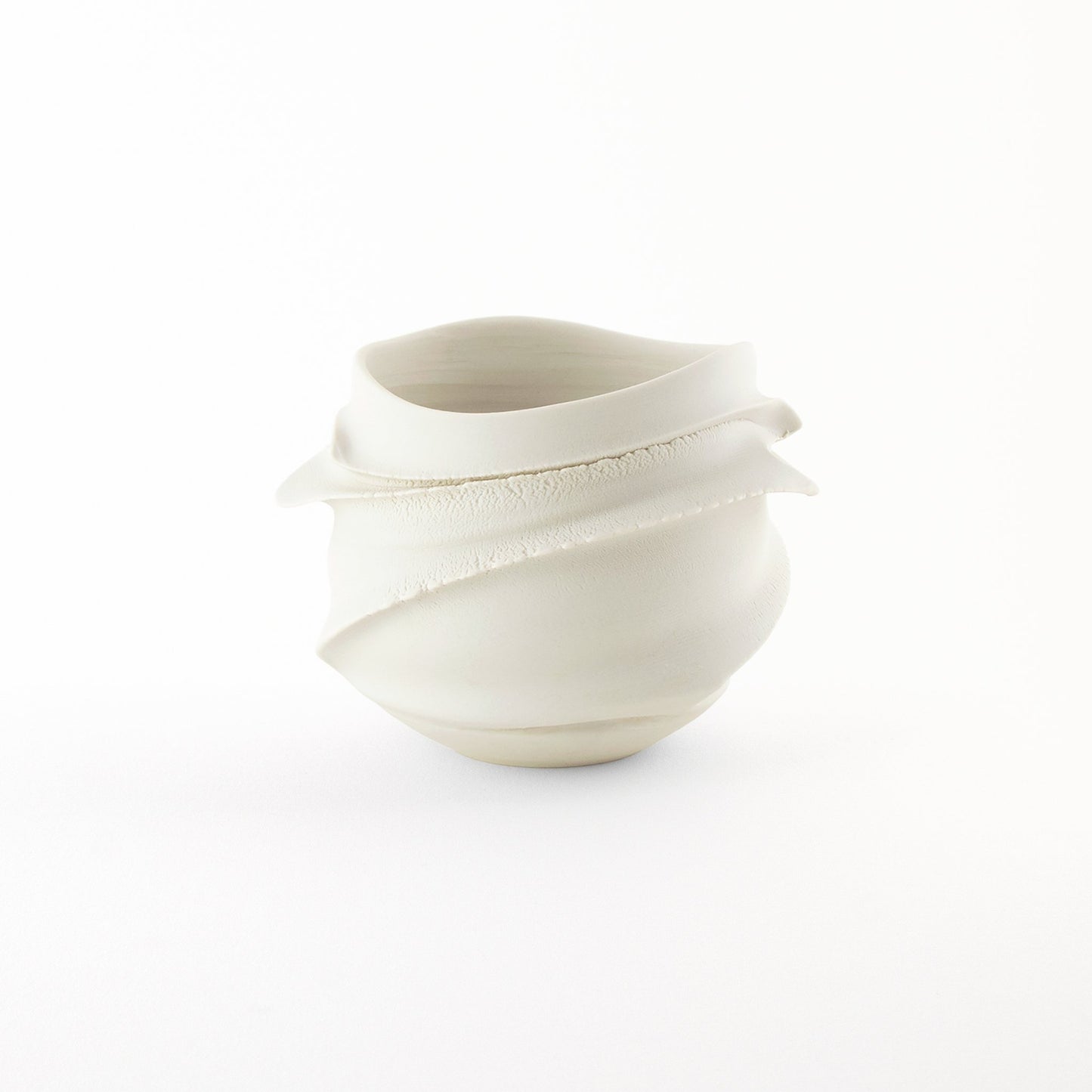 Hakuji Cachepot – a white porcelain planter with flowing swirl-like ridges, crafted with a sculptural aesthetic.