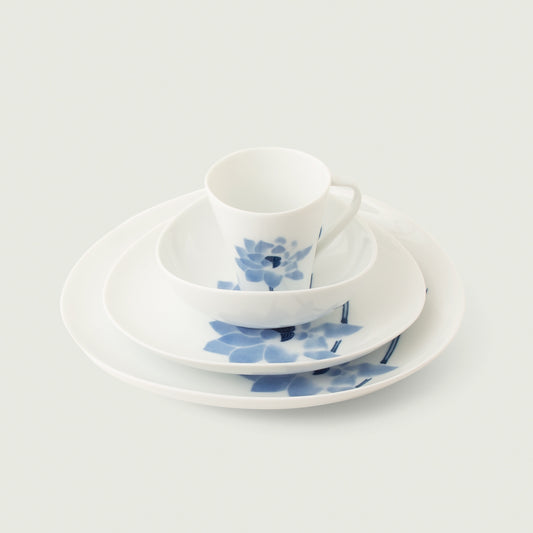 Hasu Japanese 4-piece dinnerware set - cup, bowl, salad, dinner plate. Features a blue lotus on a glossy white background.
