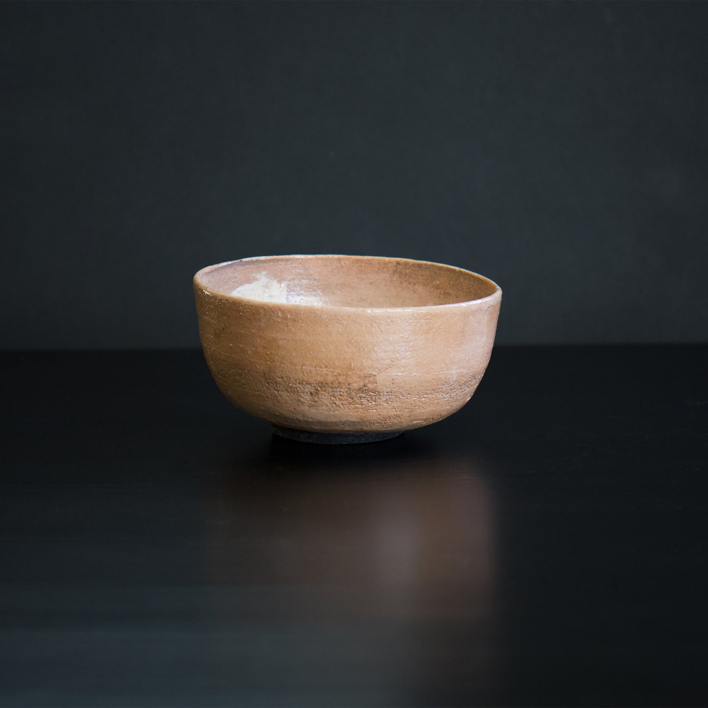 This is a serene pink matcha tea bowl, called "chawan", which is a type of unique tableware. It was carefully made by a Japanese artist who is currently based in France. The surface of the bowl retains the texture of the clay used to make it, which adds to its beauty.