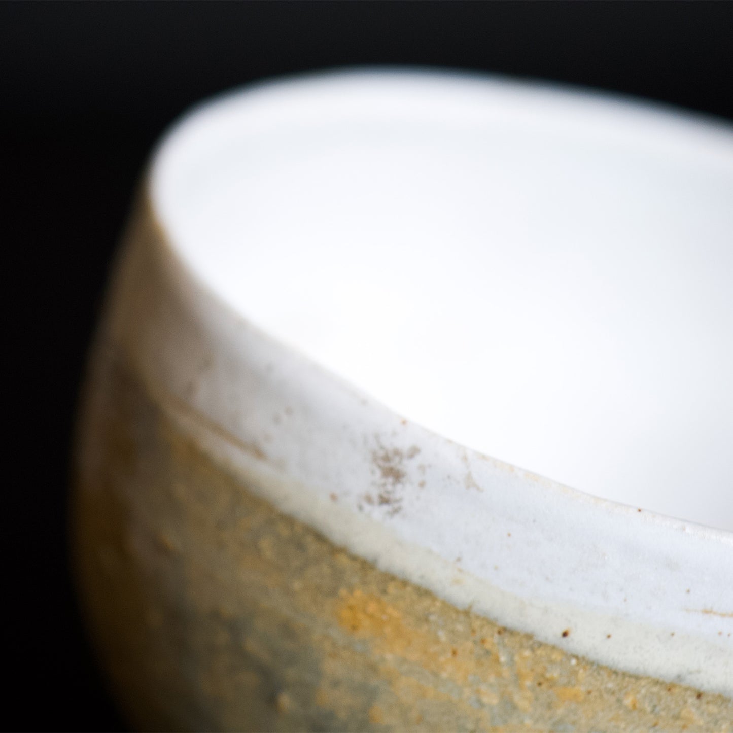 Close up view of the edge of the bowl. The contrast of matte white glaze and earthy beige color is very beautiful.