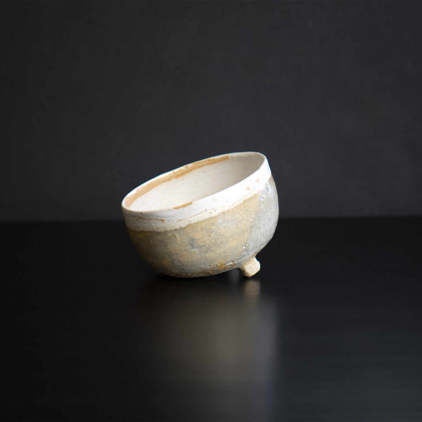 Other side of the view. The outside of the bowl is glazed with beige earthy color. The botom has less glaze and it has natural clay feeling.