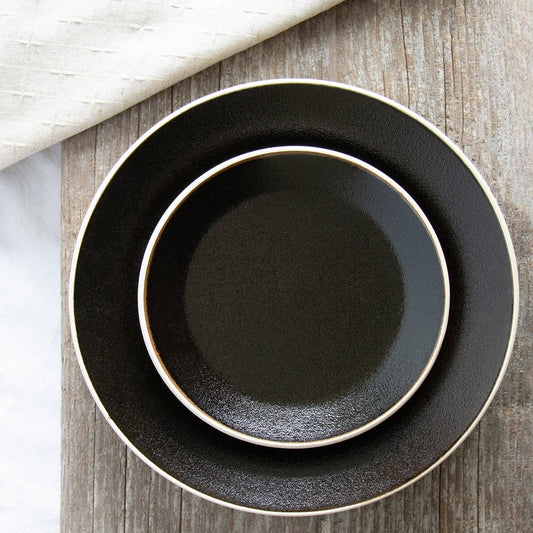 Black textured plates encircled with an off-white rim