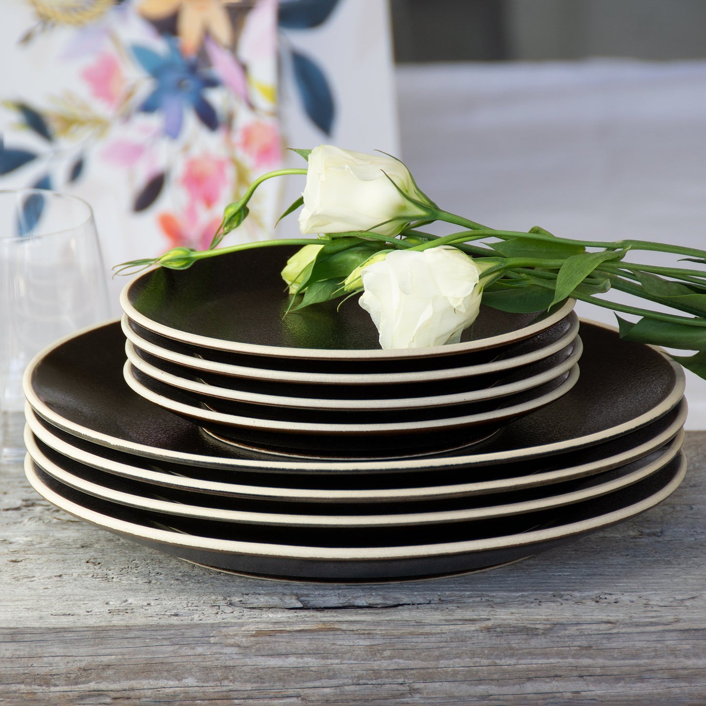 Stacked black with off-white rimmed plates creates a sophisticated look for any celebration