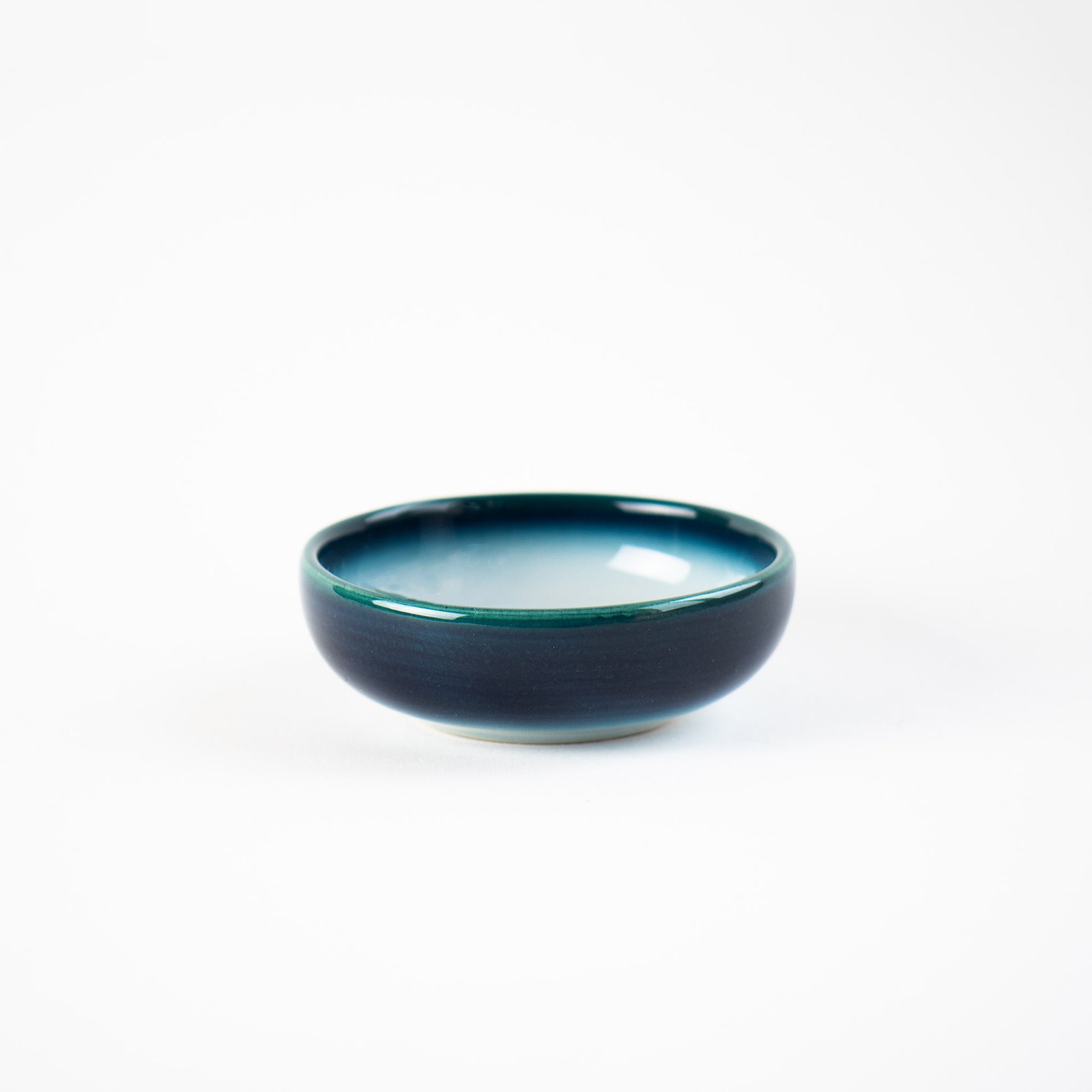 Isolated Shima White shoyu dish showing white center and midnight-blue edge, handcrafted by Yoshito Takenishi.