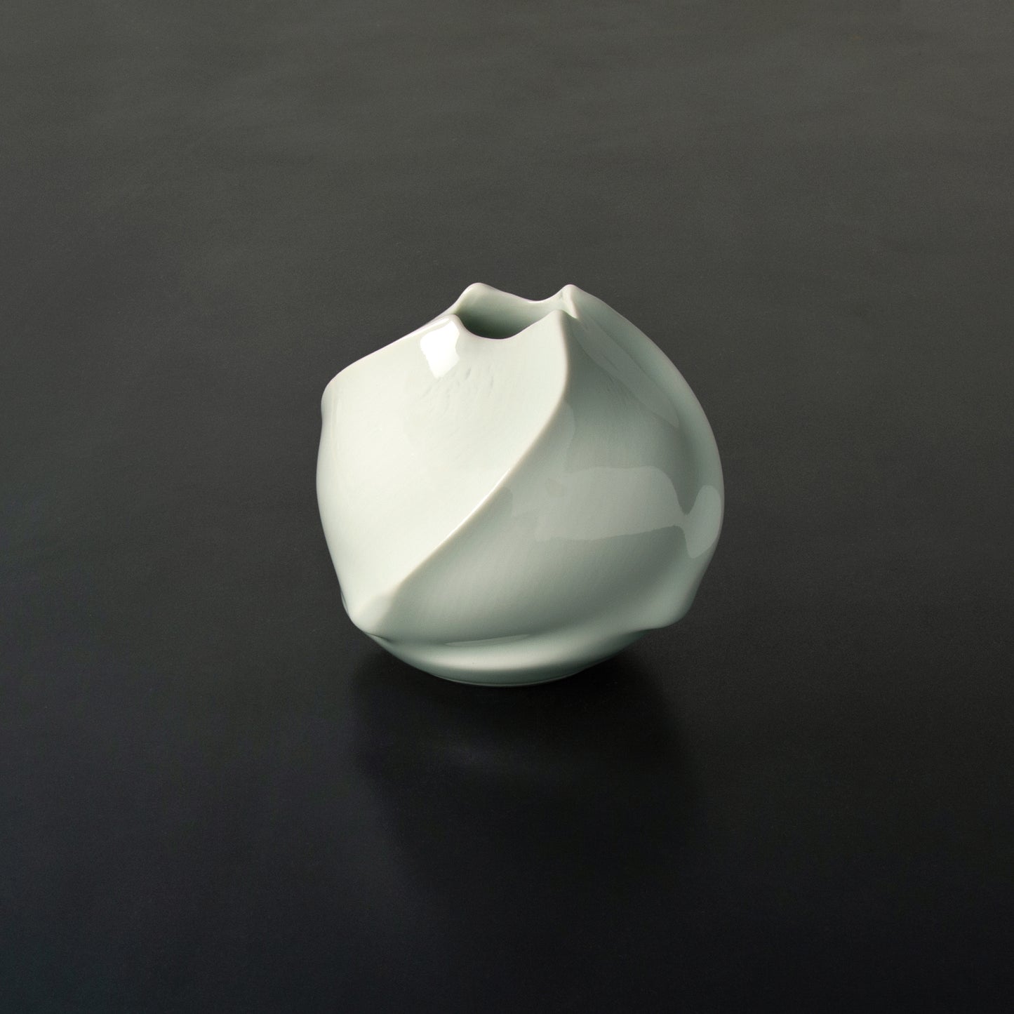 Elegant organic sphere-like Hana vase swirling raised ribs terminating at opening 4 wave-like points. Simple beauty. rare to find. flower vase.