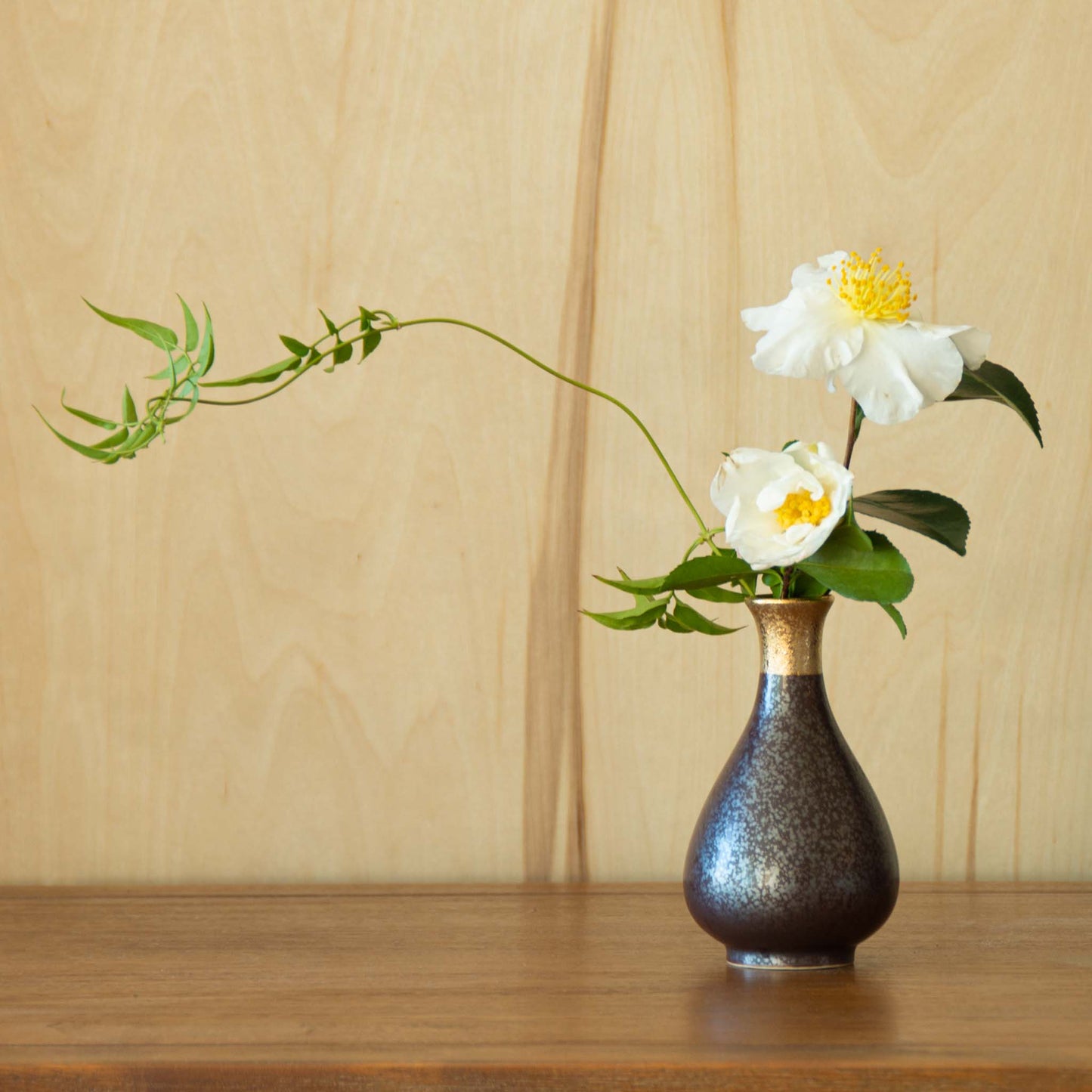 sake container vase with green foliage combined with white camelia