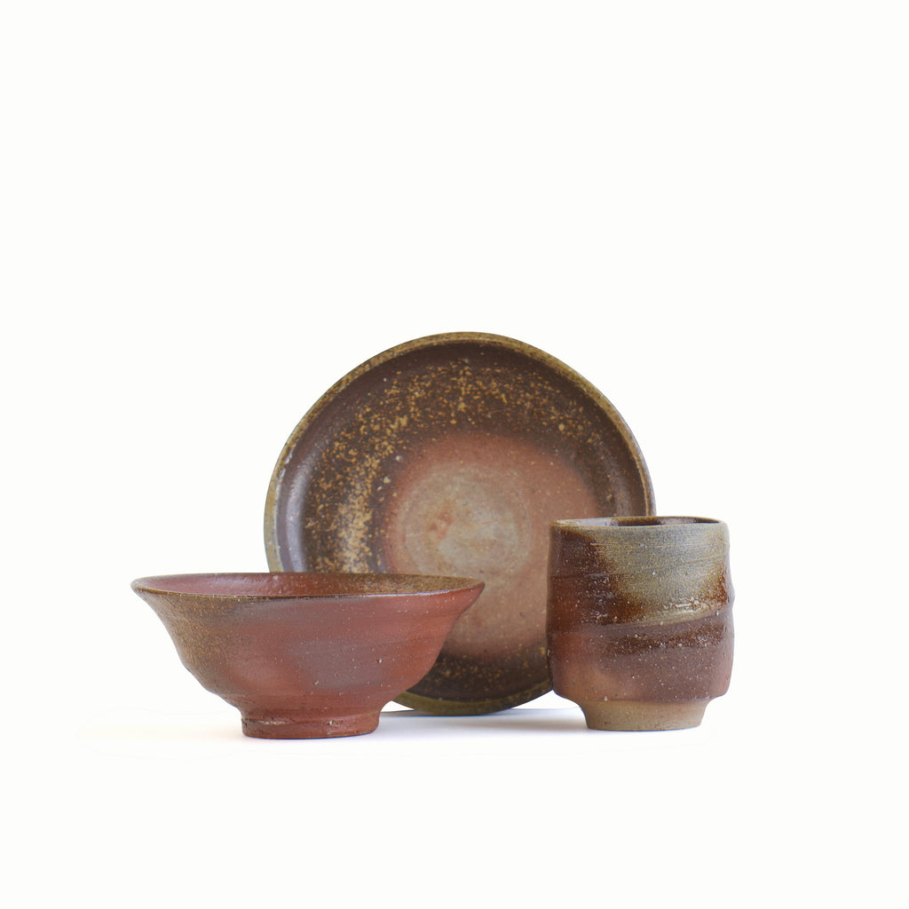 A reddish-brown dinnerware set consisting of a small 6-inch plate, a rice bowl, and a teacup. One-of-a-kind. Top quality.