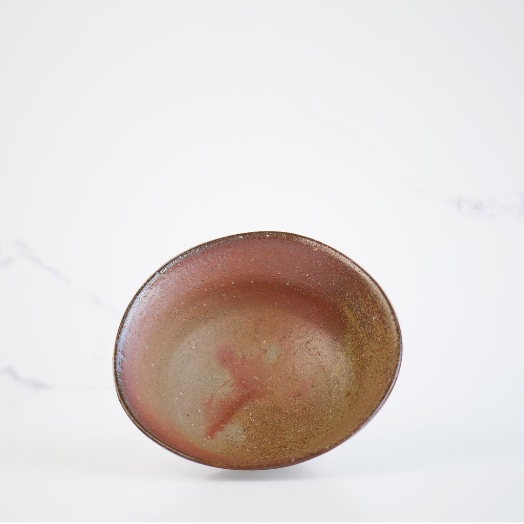 An inside view of the rice bowl, revealing a partially golden brown shade on half side of the bowl. Elegant and authentic bizen pottery.