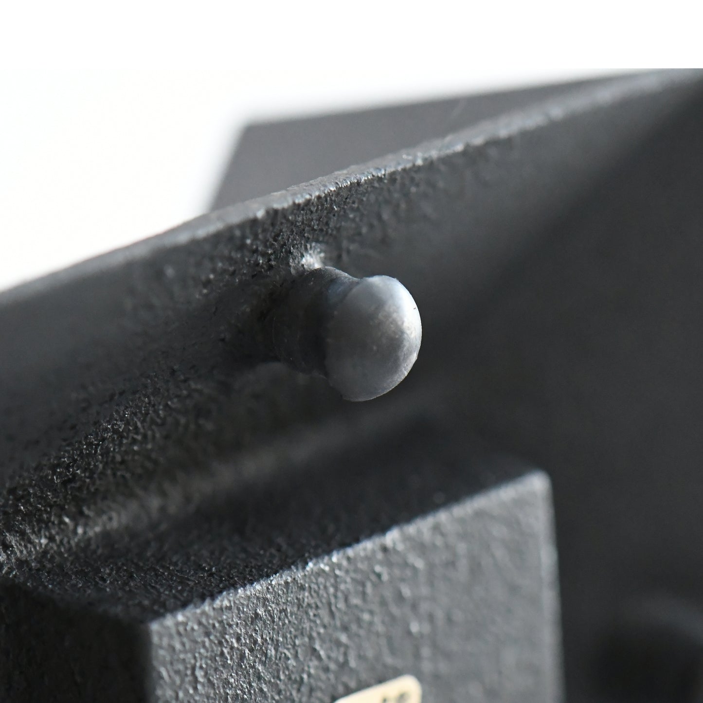 Close-up of cast iron tea incense burner foot, showing textured black surface and handcrafted detail.