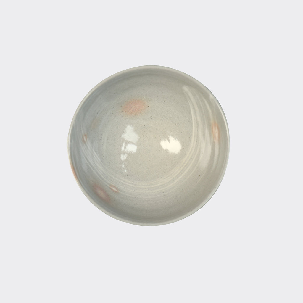  A top view of a Mashiko bowl, showcasing a glazed interior with swirls and specks of orange on a gray base. Made in Japan.
