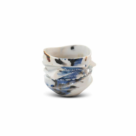 Artisan guinomi sake cup in porcelain with indigo and brown glaze layers and natural sculptural ridges.