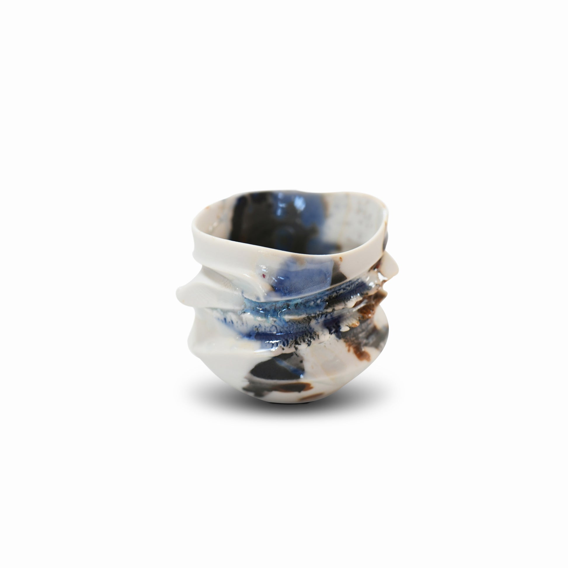 Handcrafted porcelain guinomi with flowing blue, white, and brown glazes and an organic, folded texture.
