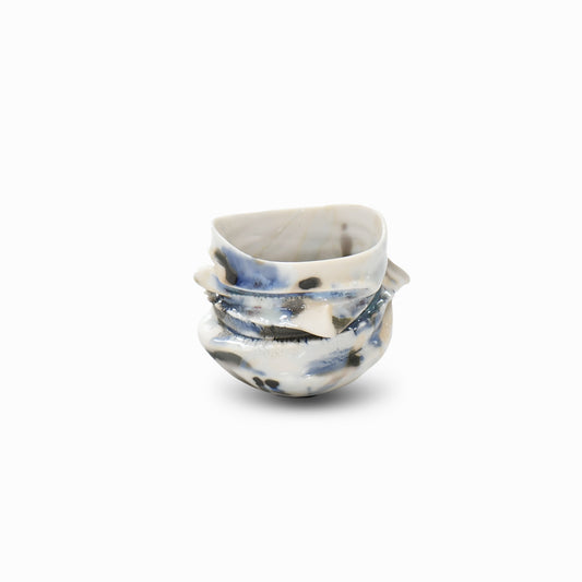 Rear view of artisan porcelain guinomi featuring layered blue and black glazes and sculptural ridge details.