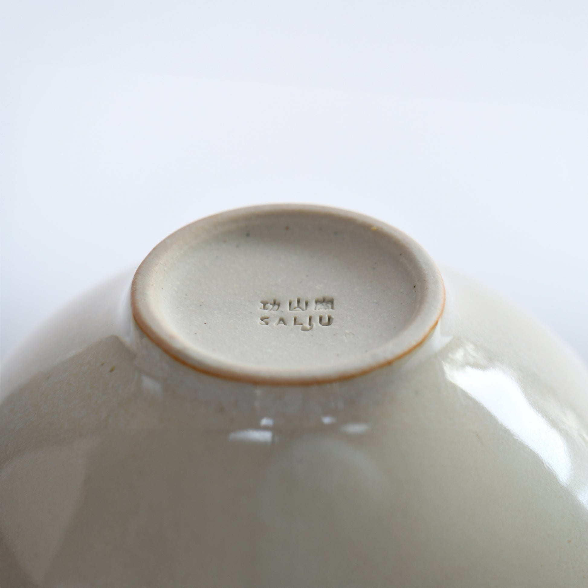 Bottom view of Yuhaku matcha bowl with Kozan Kiln stamp and foot ring detail