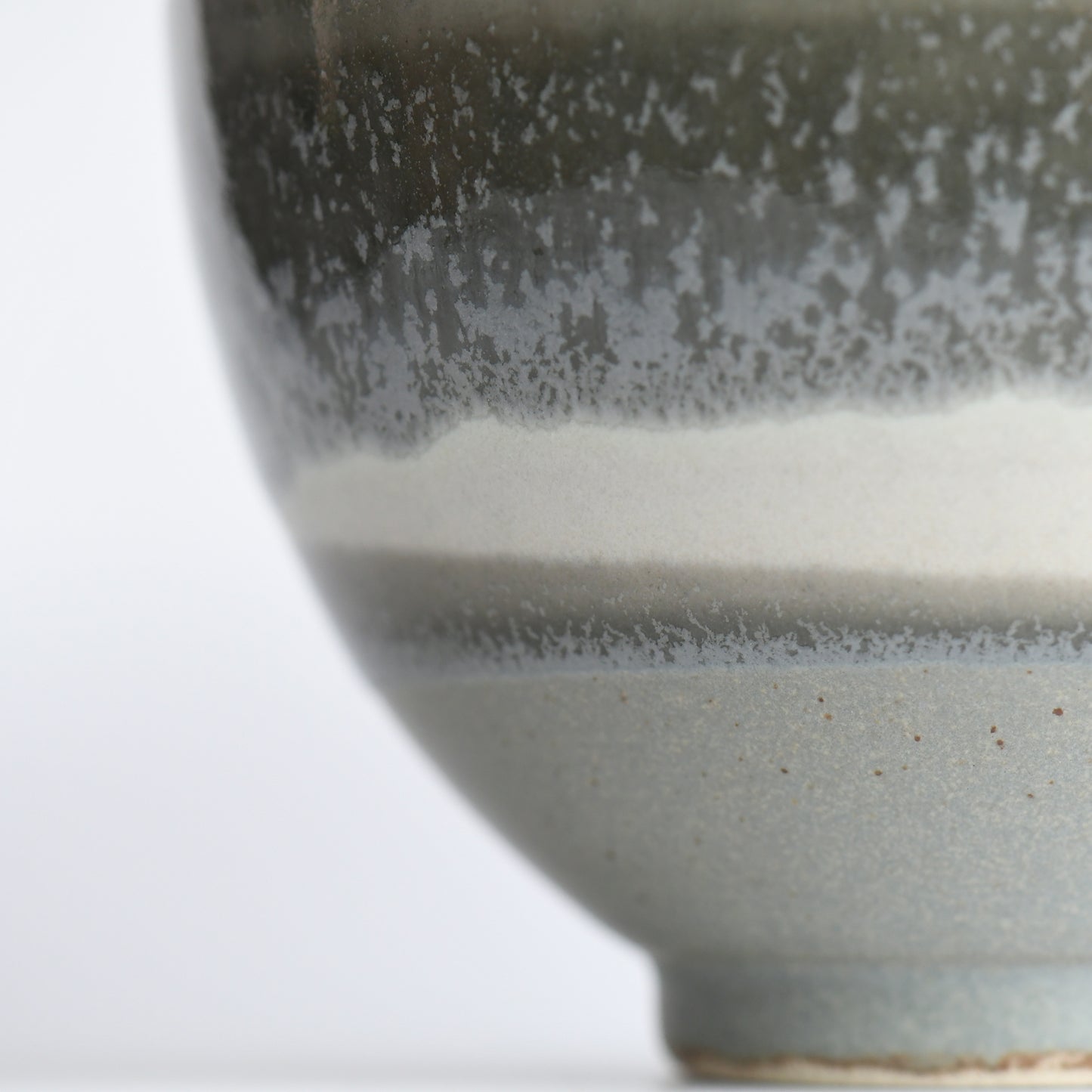 Angled detail of Yusui matcha bowl highlighting textured matte glaze and earthy moss tones