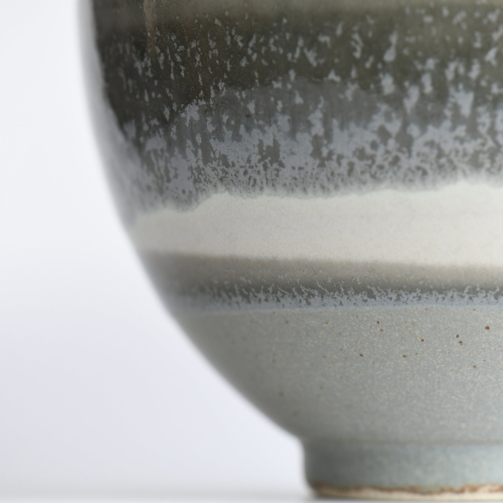 Angled detail of Yusui matcha bowl highlighting textured matte glaze and earthy moss tones