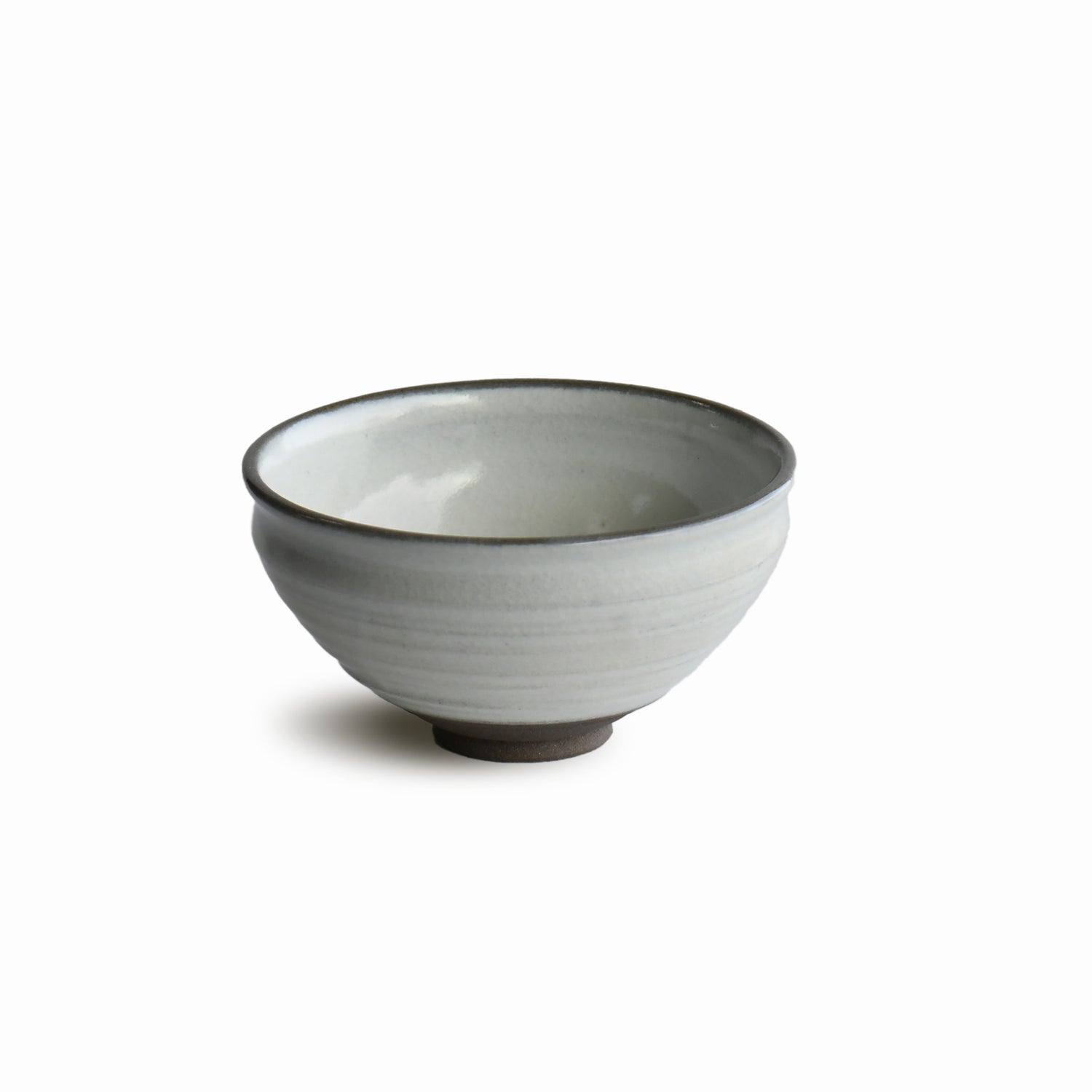 Angled view of Hakuei chawan by Shinko Kiln highlighting curved form and subtle shadow beneath the rim