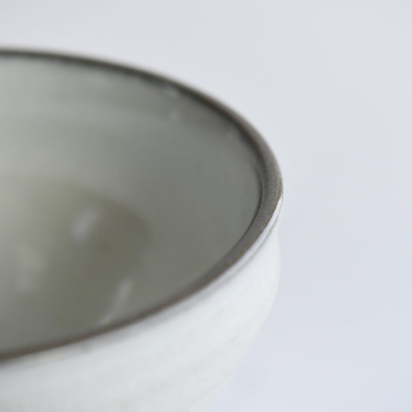 Close-up of Hakuei chawan rim with soft grey edge and smooth glazed interior