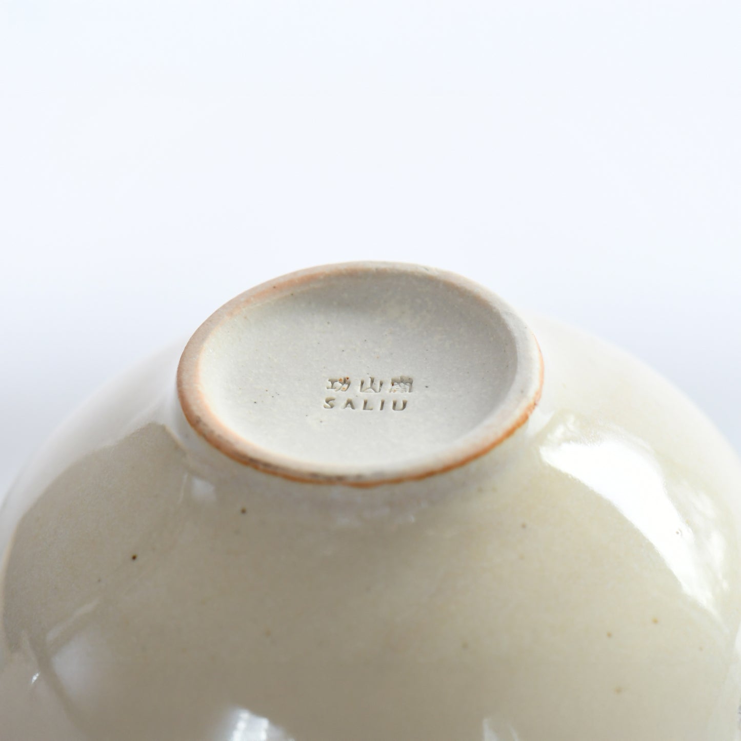 Bottom view of Yusumi matcha bowl with Kozan Kiln stamp and foot ring detail