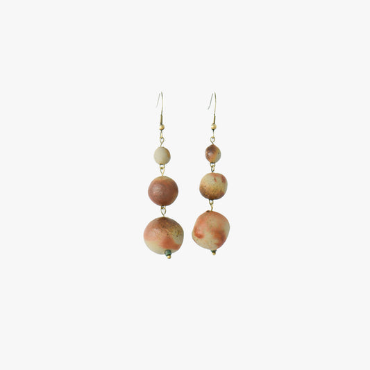 A pair of handcrafted earrings featuring earthy-toned ceramic beads by renowned Bizen potter Manabu Suehiro. The design includes three graduated ceramic beads with a warm, organic texture, complemented by brass posts for an elegant and timeless look. Set against a light background.