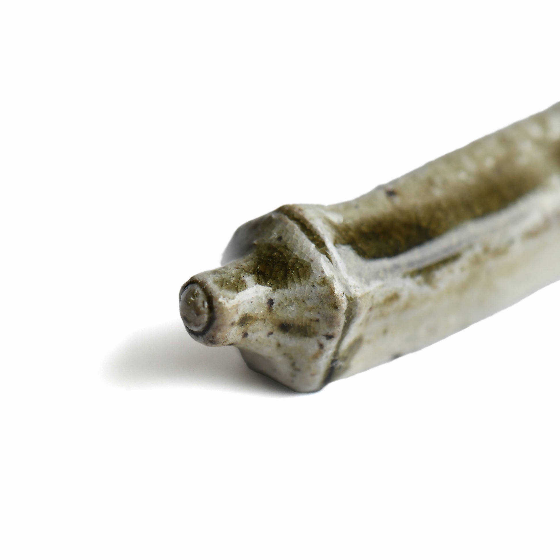 Close-up of the handmade Bizen okra chopstick rest showing natural glaze and texture