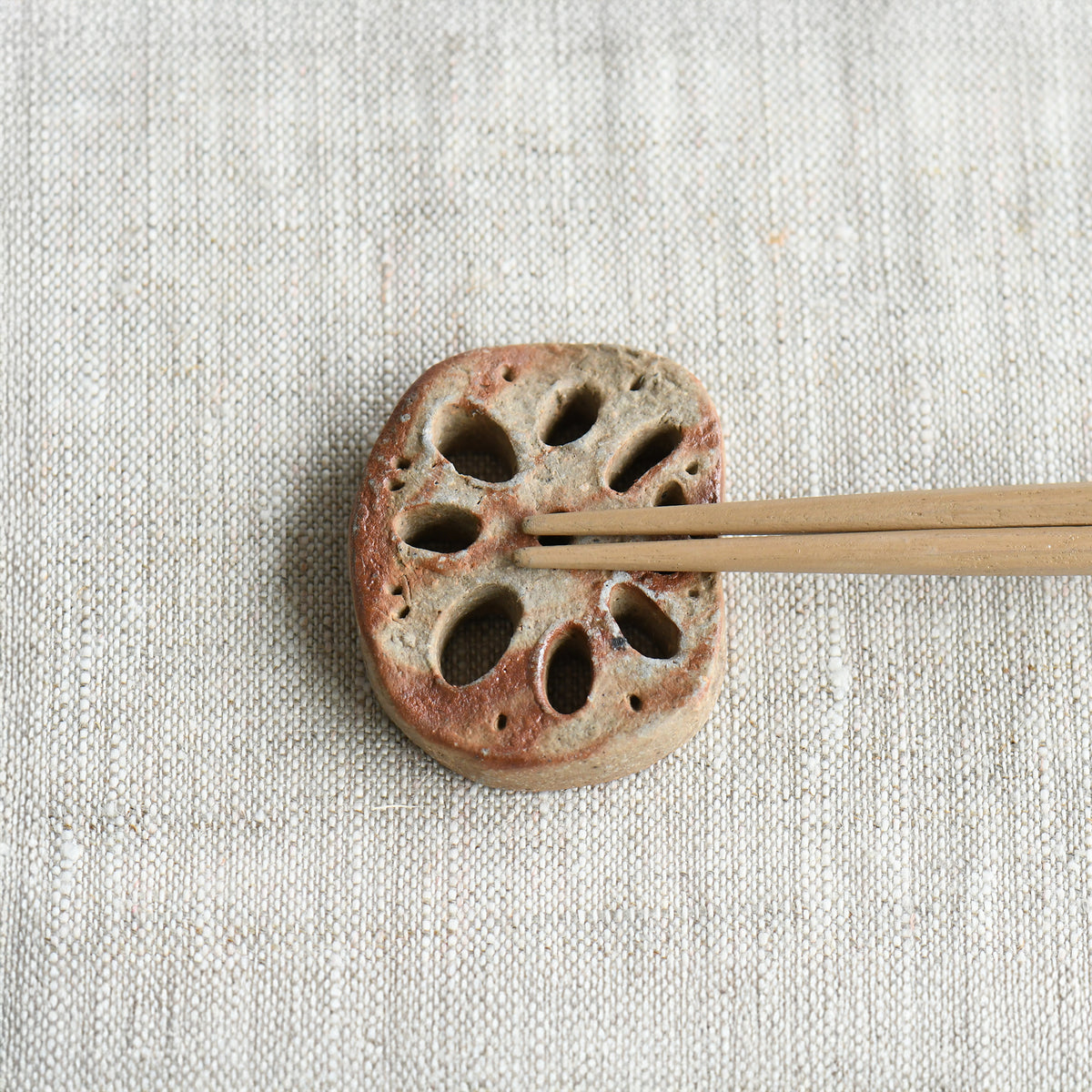 Bizen lotus root chopstick rest by Masato Miura shown with wooden chopsticks