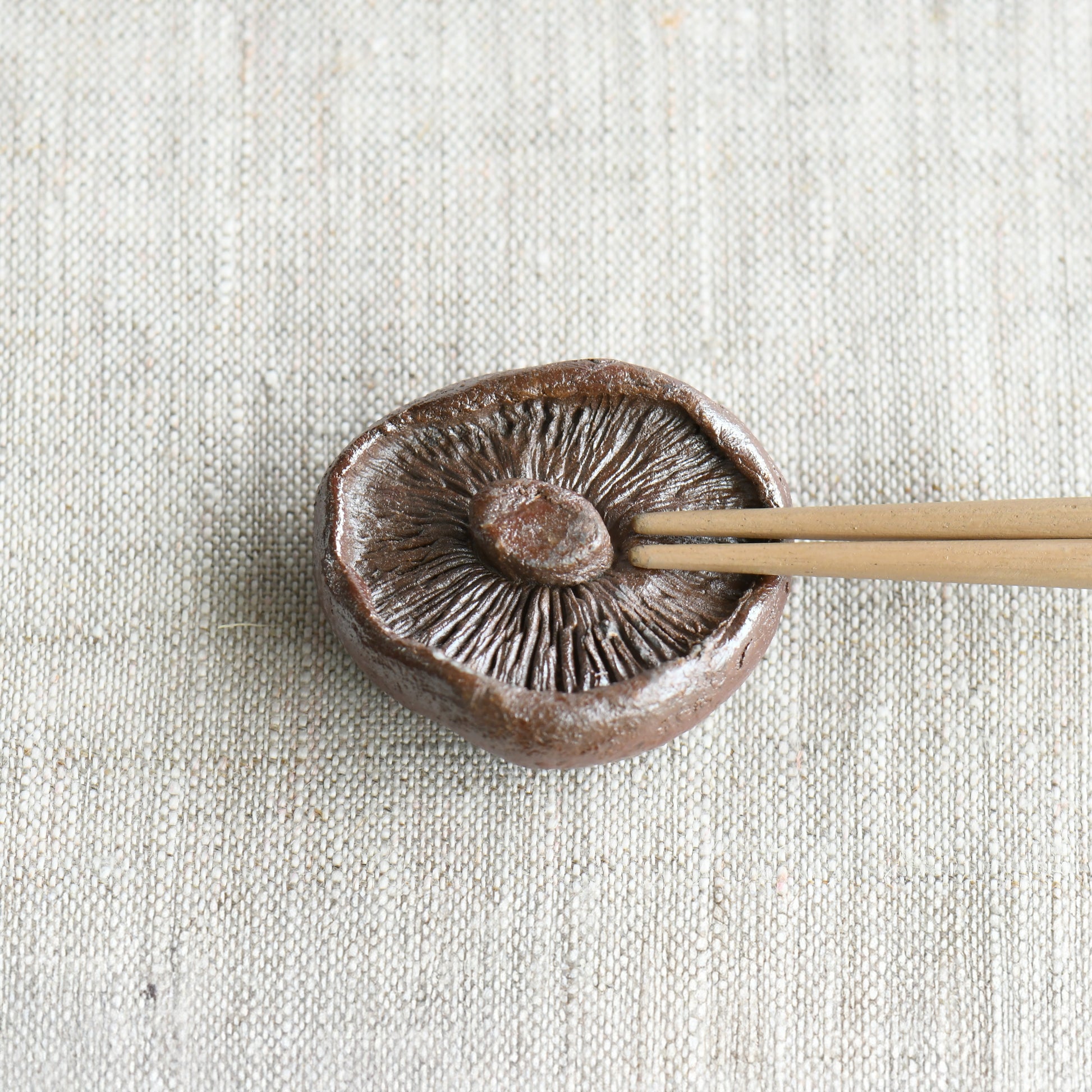 Bizen shiitake chopstick rest by Masato Miura shown with wooden chopsticks