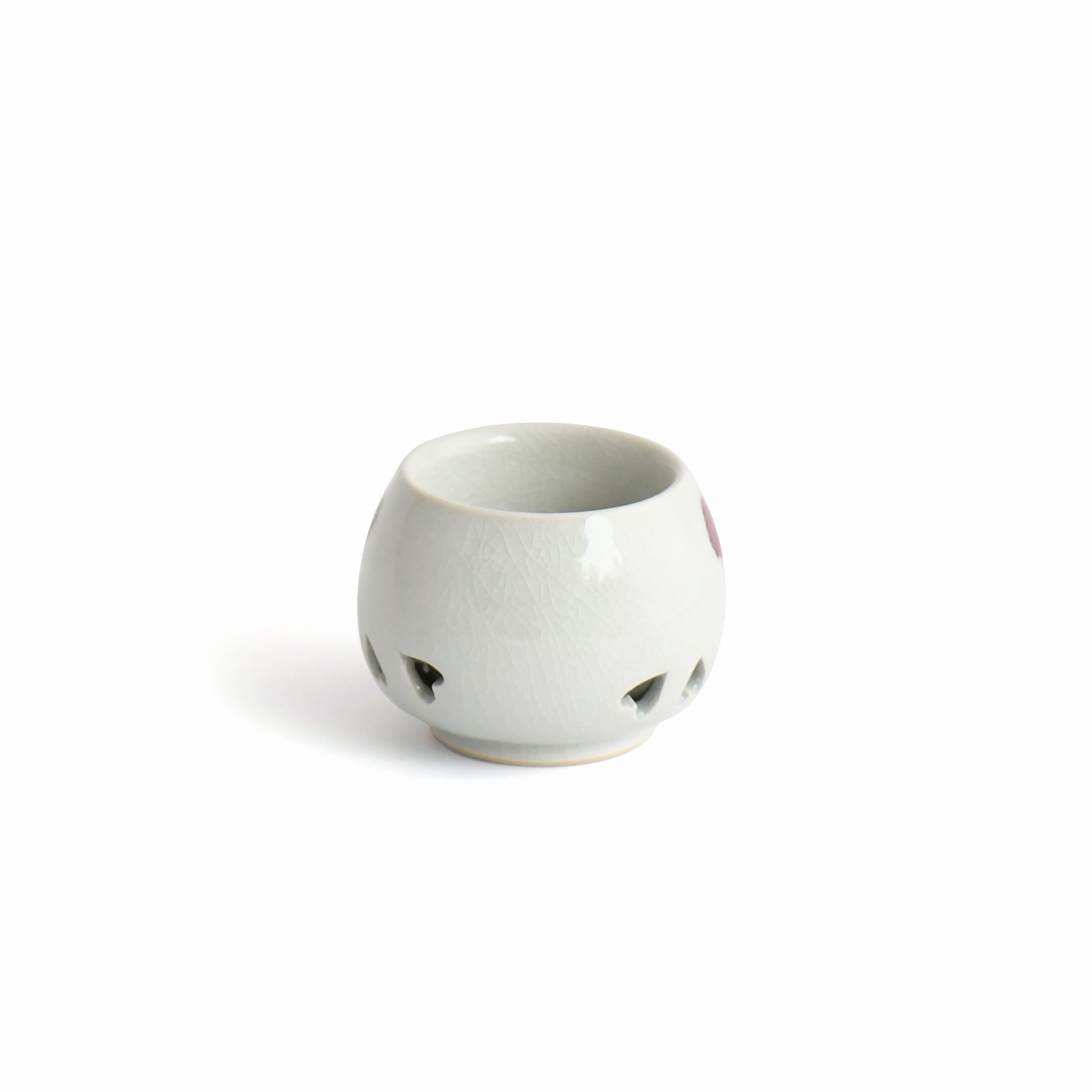 Back view of white guinomi cup with delicate crackle glaze and cutouts
