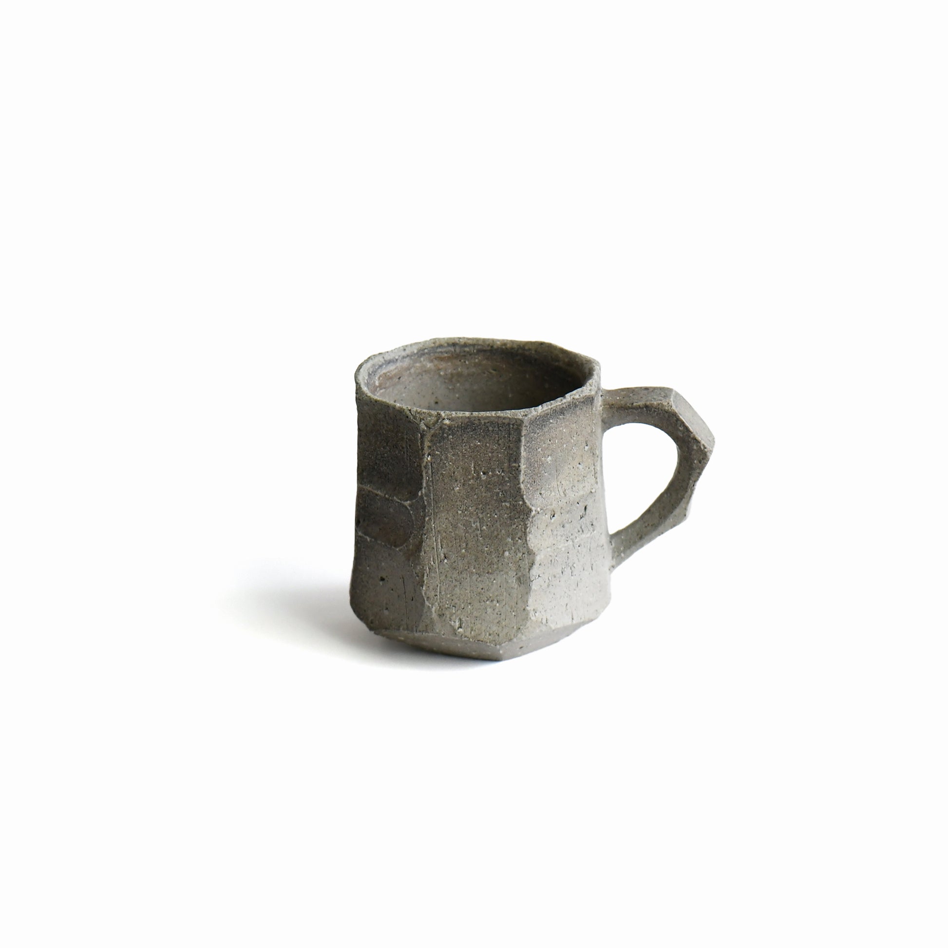 Seihitsu Sueki Mug Medium #2 by Manabu Suehiro, 6.5 oz handmade stoneware mug with faceted ash-gray surface and angular handle, front view on white background.