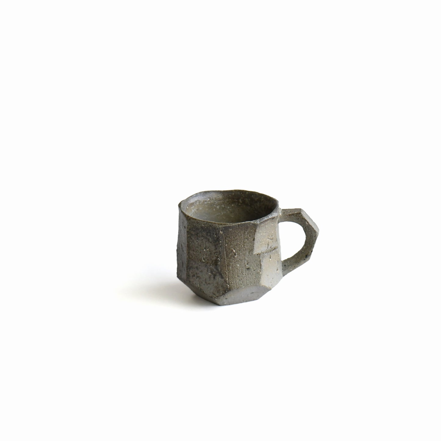 Seihitsu Sueki Mug Small #2 by Manabu Suehiro, 4 oz Japanese stoneware mug with faceted ash-gray surface and subtle smoky firing tones, front view.