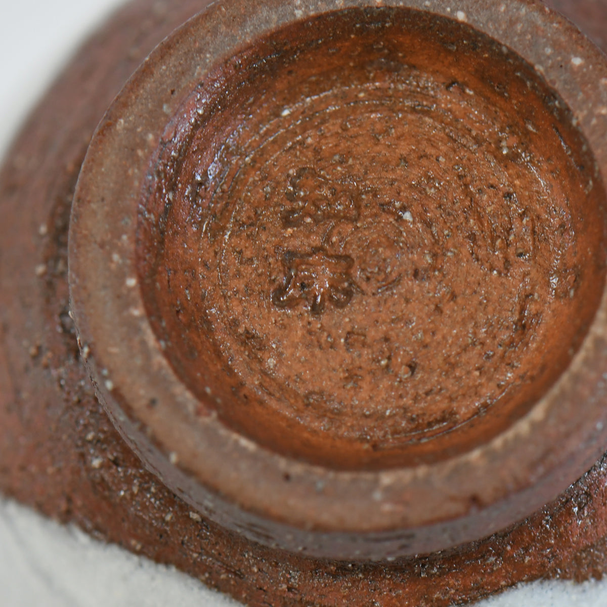 Base of Shirayuki yunomi by Takeshi Honda showing exposed Mashiko clay and artist’s mark