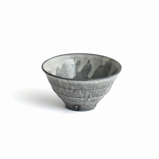 Sumine Rice Bowl by Takeshi Honda with flowing white glaze over a charcoal-gray textured surface.