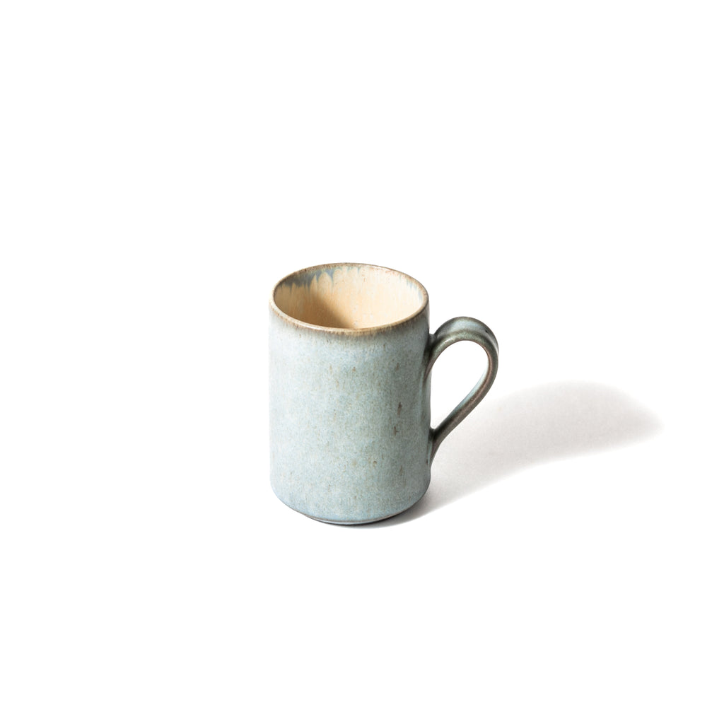 Inside of the mug is beige. Blue glaze is slightly shown on the edge.