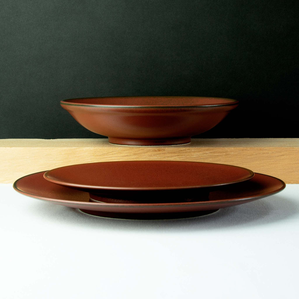 Pasta bowl with salad dish and dinner plate with slight black outline at rim.