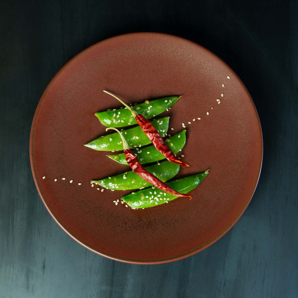 Deep red plate provides a complimentary background for leafy greens or vegetables.