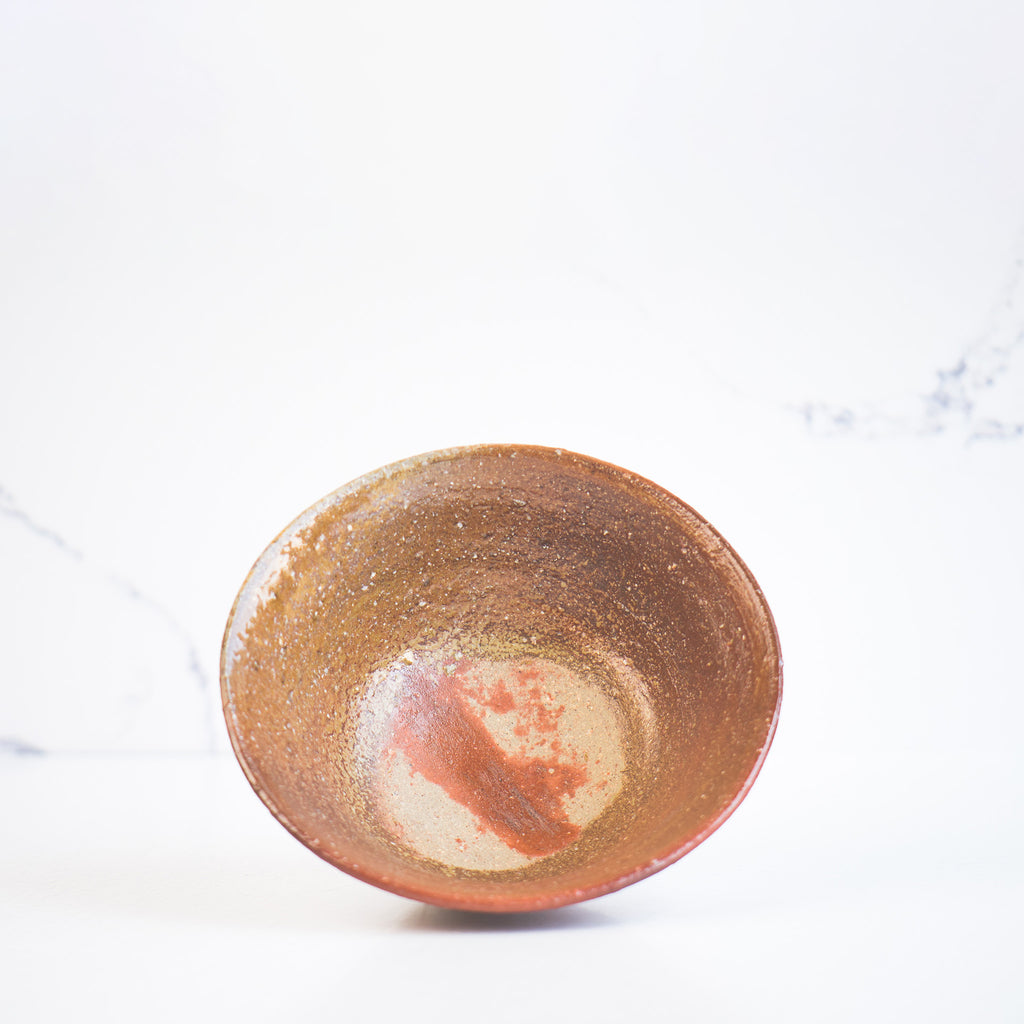 Experience traditional pottery design with this rice bowl's rich reddish-brown interior and striking red lines on a beige base at the bottom.
