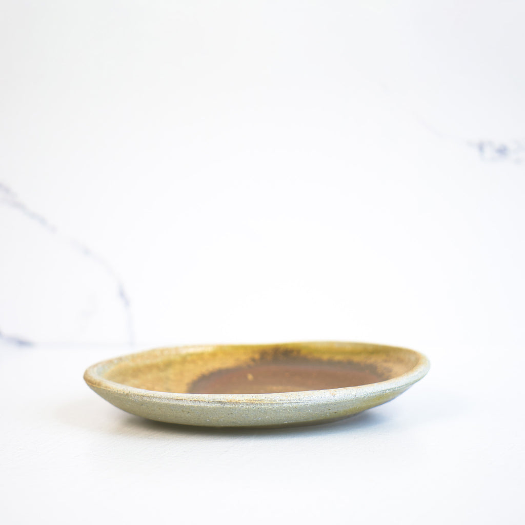 Side view of a gently round ceramic plate, featuring a smooth surface and a subtle curve that adds elegance and dimension to any table setting.
