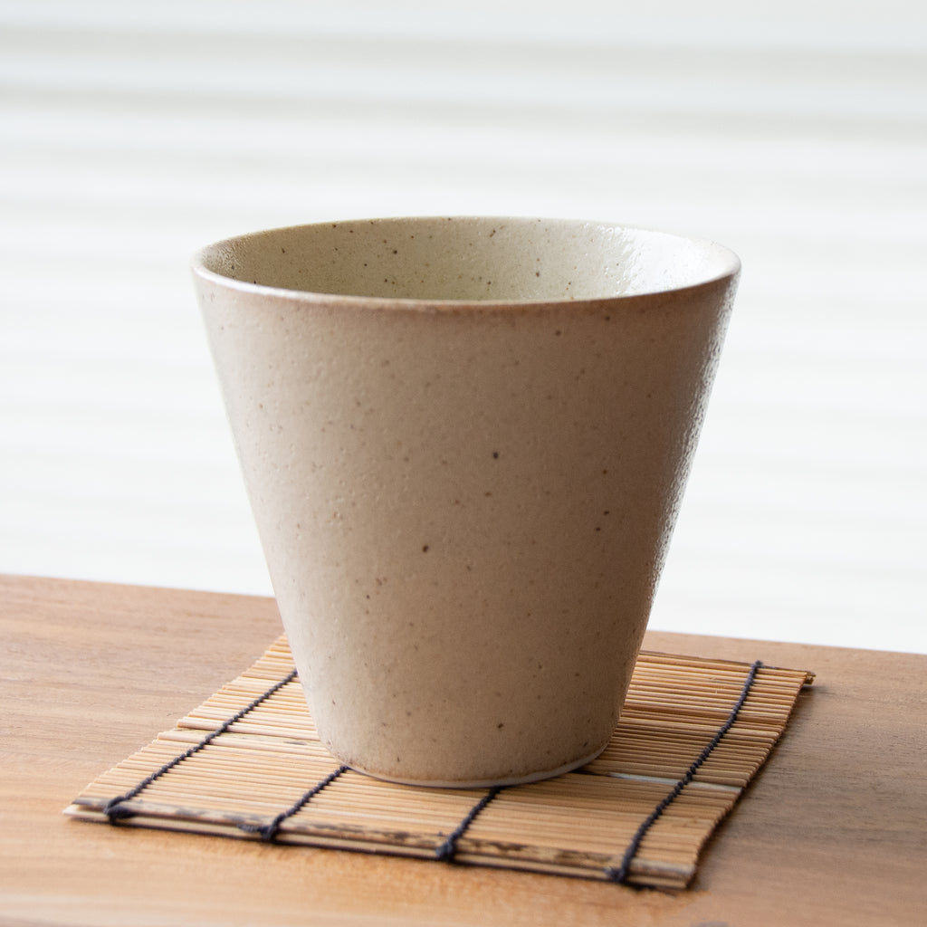 Speckled off-white tall tapered tea cup