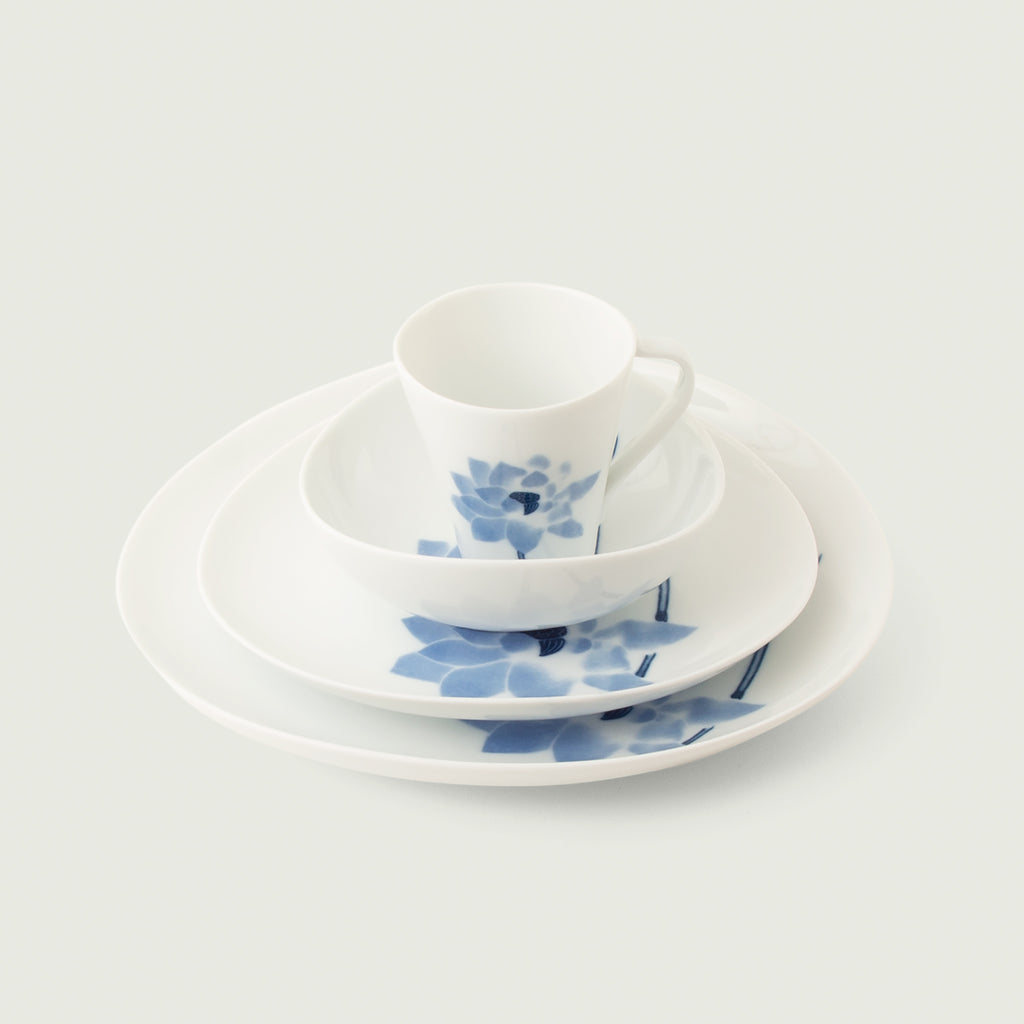 Hasu Japanese 4-piece dinnerware set - cup, bowl, salad, dinner plate. Features a blue lotus on a glossy white background.  