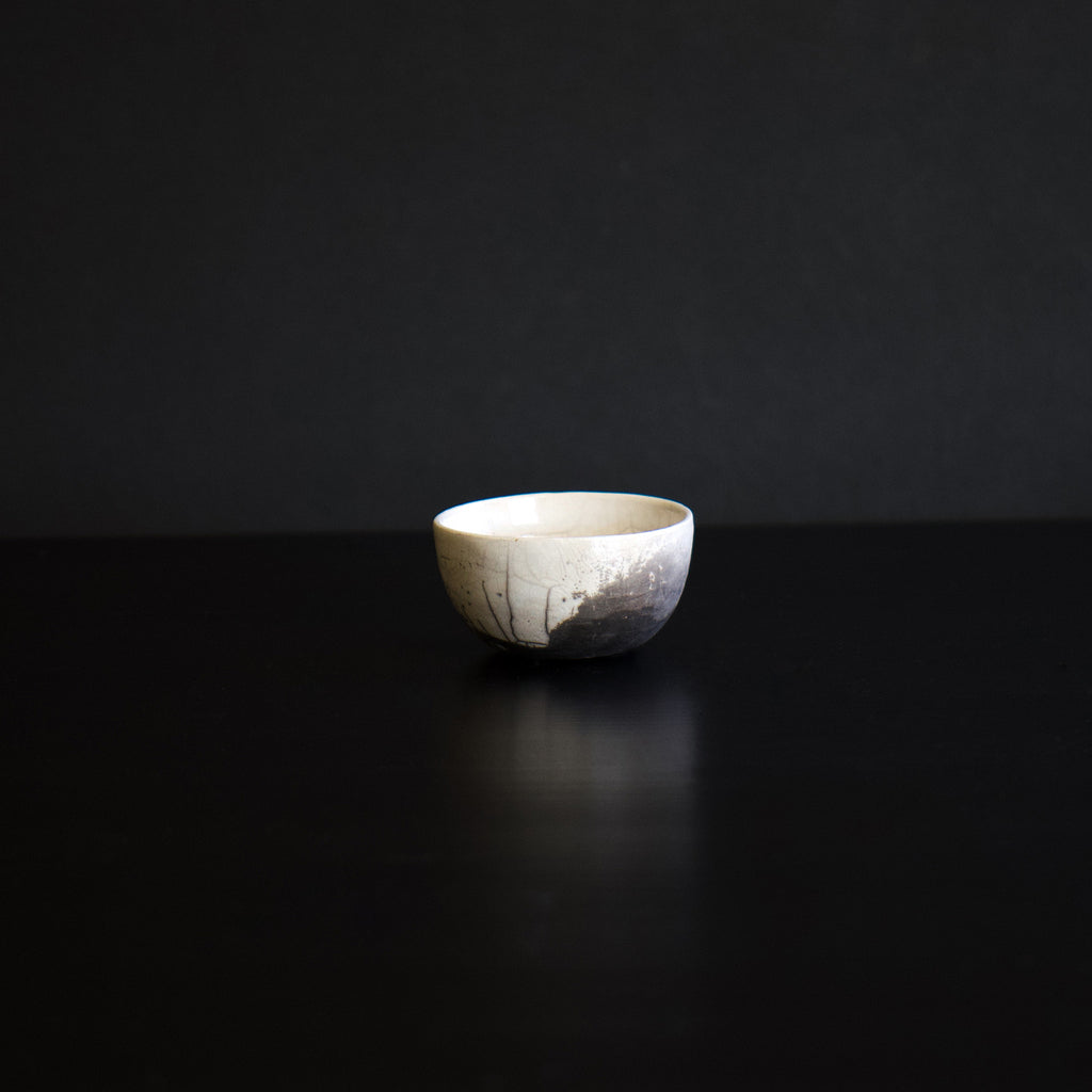 A ceramic sake cup with an off-white exterior and beautiful shades of gray. It's like Japanese sumi painting art.