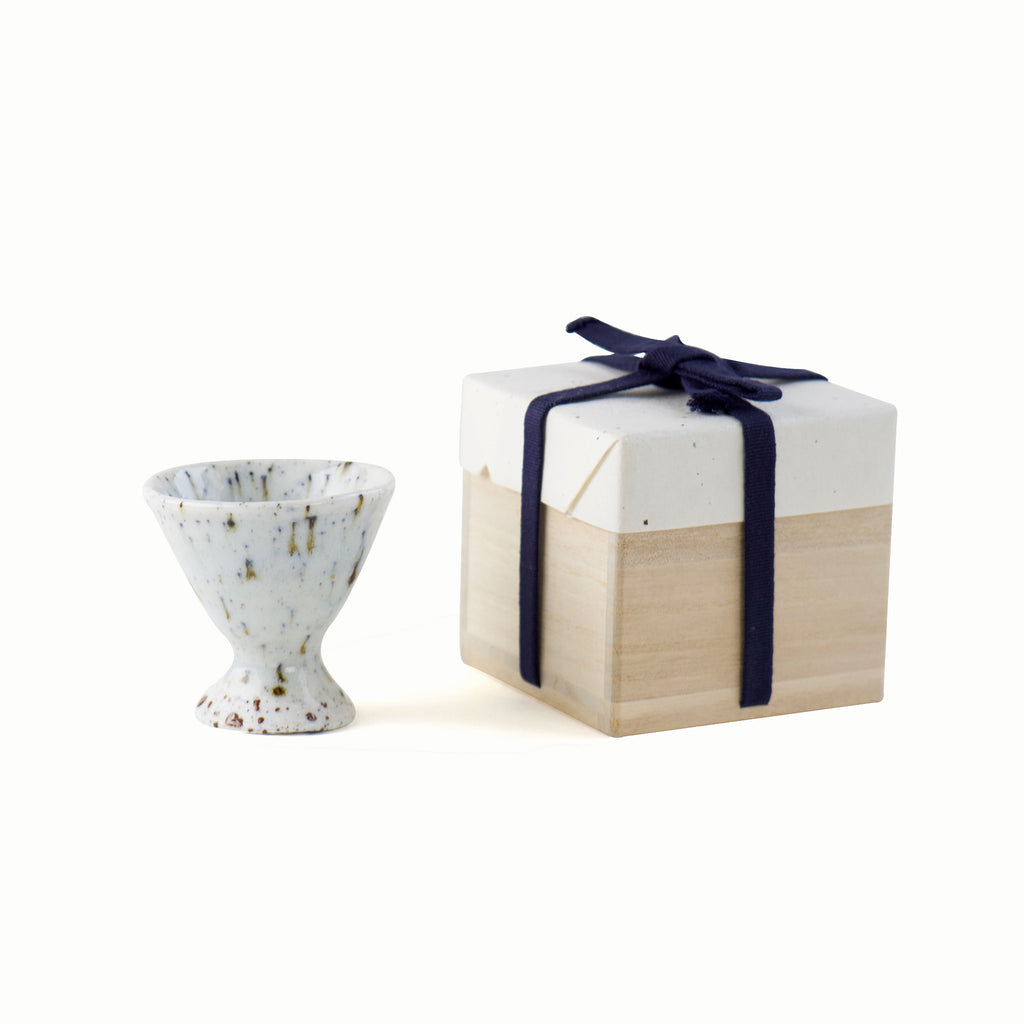 White sake cup with wooden box. The box is tied with dark navy strings and this is a traditional way of wrapping pottery. 
