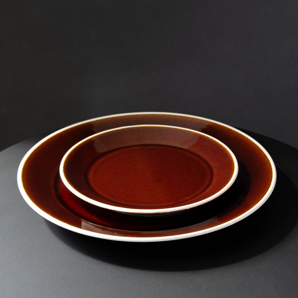 Medium and small plate with deep rust, orange, red glaze encircled with an off-white rim 