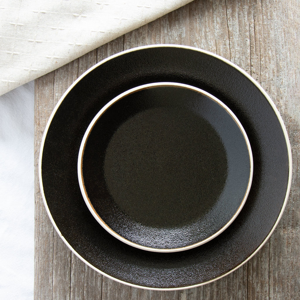 Black textured plates encircled with an off-white rim 