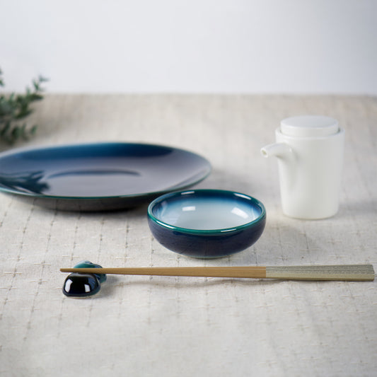 abletop scene featuring Shima White shoyu dish with matching plate, chopsticks, and porcelain cruet.